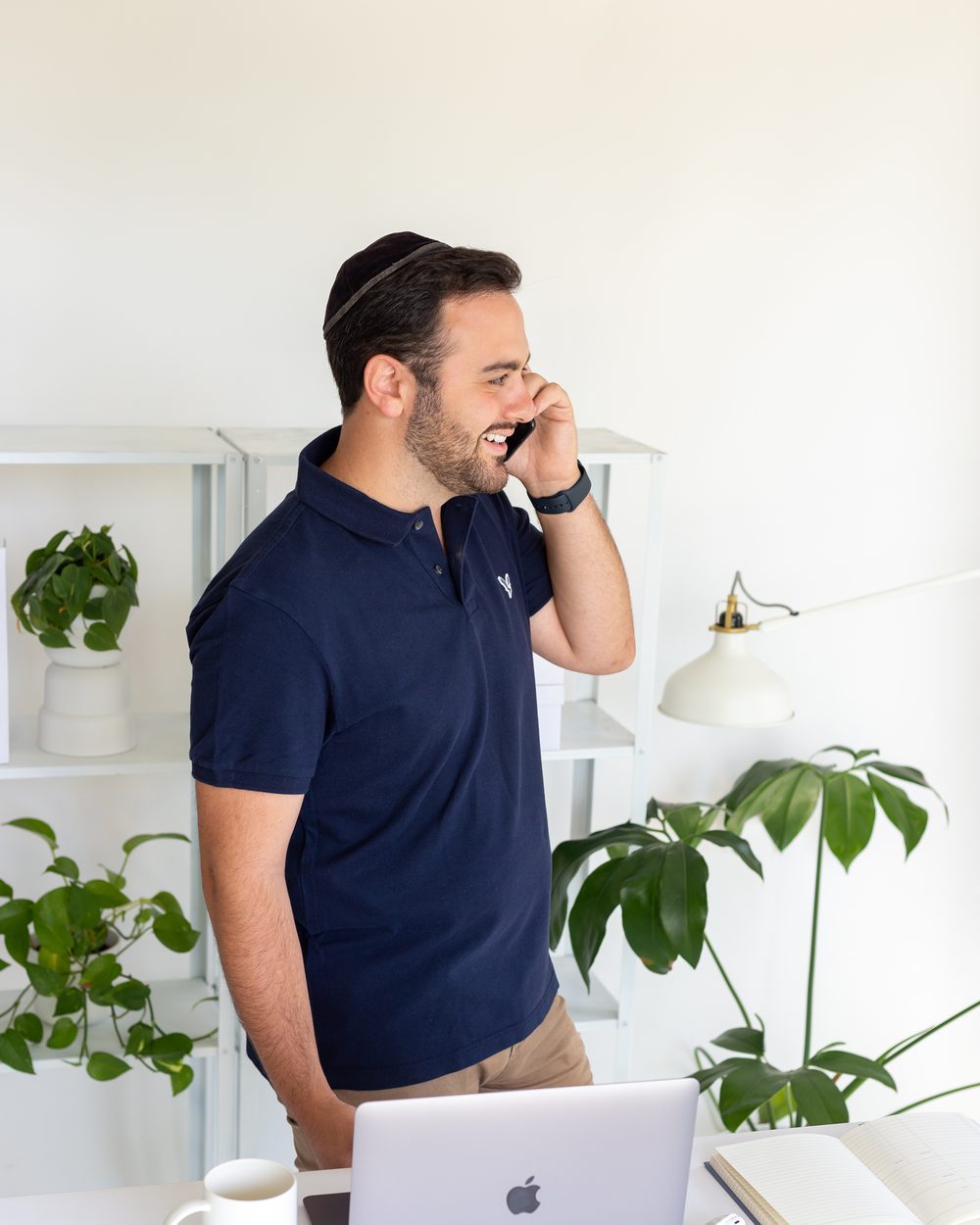 Abe Braha standing at a desk, on a phone call