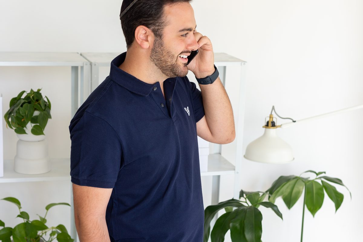 Abe Braha standing at a desk, on a phone call